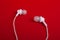 White headphones earphones on a red background