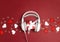 White headphones with gift box and decorative hearts on a red background. St. Valentines Day music gift concept