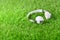 White headphones on the green artificial grass .
