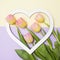 White heart-shaped frame and tulips on yellow purple background.