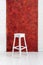 White high wooden stool with a red textured background. Bar chair in white wooden minimalist room. Stool. Bench
