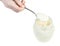 White honey in steel spoon over glass jar isolated