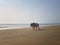 White horned bull walks down the sandy beach opposite the sea. Indian cow, holy cow, sacred animal