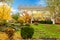 White horse farm American house during fall with green grass.