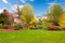 White horse farm American house during fall with green grass.