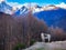 White horse standing on a hill having Mount Siguniang in the background