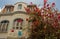 The white house with balcony and red flower bush in front of, Fort de France, French West Indies.