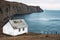 White house on the beach. A lonely house on a promontory by the sea. Seascape. An old abandoned house by the sea. Copy space