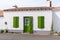 White house facade with green shutters blinds and door in Noirmoutier island France