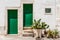 White house wall facade, green door and shutters