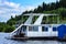 White houseboat parked on the shore of the reservoir