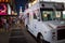 White ice cream truck on a crowded street at night in New York C