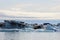 White Icebergs in the middle of an ocean on a sunny day