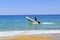 A white inflatable motor boat with a man on board moves along the shore