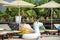 White inflatable unicorn with rainbow mane on a tropical poolside