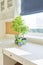 White interior background, close-up abstract details, table, roman blinds, window, blue flowerpots