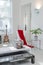 White interior of luxury apartment. Chair, guitar, plant, candles.