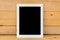 White ipad on brown wood table background