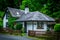 White Irish cottage surrounded by colorful flowers and trees near Powerscourt waterfall near Dublin