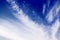 White Ñirrus clouds on dark blue sky background closeup, cirrostratus cloud, spindrift clouds, fluffy wispy cloudy skies texture