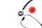 On a white isolated background lies a stethoscope and a red virus mockup.