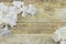 White and ivory silk flowers on a rustic wooden white washed background.