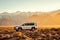 A white jeep stands alone in the vast and barren desert, parked in the golden sand under the bright sun