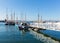 White jetty walkway boats and yachts in marina