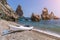 White kayak on an isolated pebble beach against the backdrop of rocks in the sea. Copy space. The concept of travel