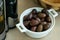 White keramic bowl full of fresh prepared olives with olive oil and bread. .Large, dark purple olives with a smooth, meaty texture