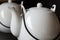 White kettles or tea pots on black background