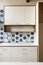 White kitchen cabinet in modern home with blue tile