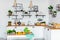 White Kitchen, Colorful Fruits and Vegetables on White Table and Wooden Counter, Pots, Plates, Boxes and Plants and kitchen