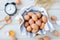 White kitchen table with fresh raw eggs, yellow yolk eggs, white heart shape sign and classic vintage clock.