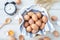 White kitchen table with fresh raw eggs, yellow yolk eggs, white heart shape sign and classic vintage clock.