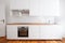 White kitchenette , newly built-in kitchen furniture frontal view with wooden worktop and board floor