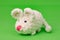 White knitted mouse, made with its own hands, on a green background