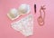 White lacery lingerie near lipstick and necklace on pink background. Woman underwear for special occasions. Composition for beauty