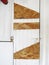 White laminated wooden door with cork patches, deadbolt and padlock. Rustic old white wood panel. Front View. Abstract texture