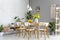 White lamps above wooden table and chairs in dining room interior with yellow flowers. Real photo