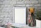 White landscape frame beside a small houseplant and watercolor supplies, painting or artwork display mockup.