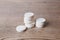 White large pills close up stand in a pile on a wooden background. Vitamins, pharmaceuticals for the treatment of diseases