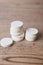 White large pills close up stand in a pile on a wooden background. Vitamins, pharmaceuticals for the treatment of diseases