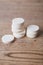 White large pills close up stand in a pile on a wooden background. Vitamins, pharmaceuticals for the treatment of diseases