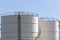 White large storage tanks under a blue sky.