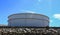 White large storage tanks under a blue sky.