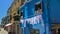 White laundry drying on blue house facade, Burano island street, life in Italy