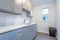 White laundry room with pale gray shaker cabinets