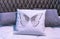 White leather pillow with embroidered butterfly in the bedroom interior