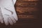 White leather welder gloves on a wooden background. A studio photo with hard lighting